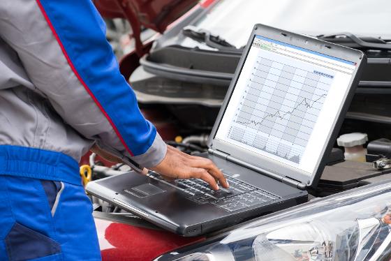 16561607-mechanic-using-laptop-for-examining-car-engine.jpg