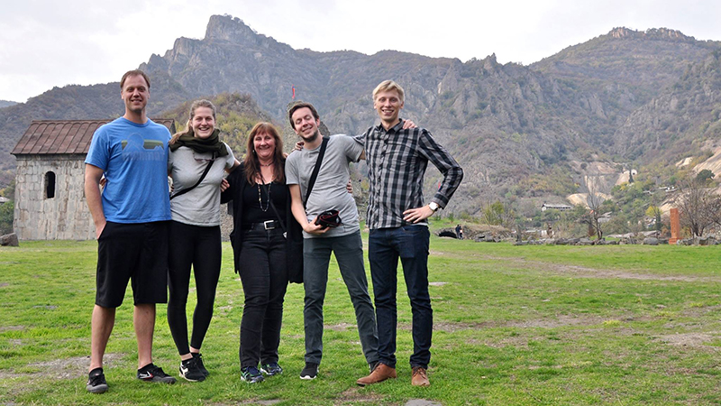Smiling people on field with hills in the background
